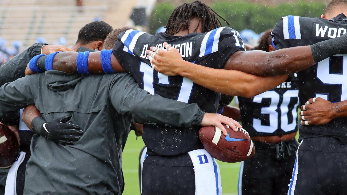 Football Team with arms around eachother