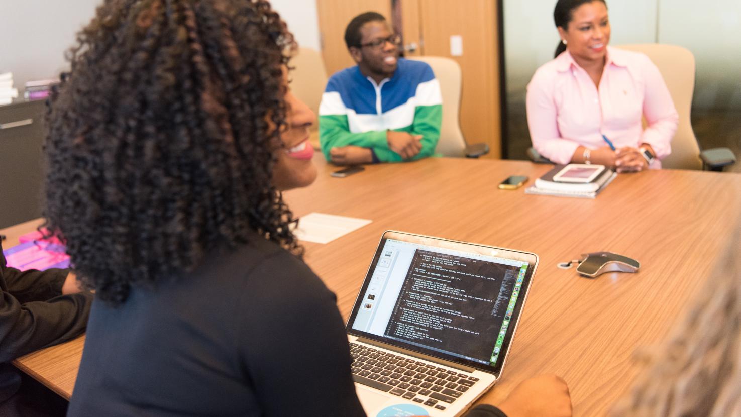 3 people in a board room discussing data