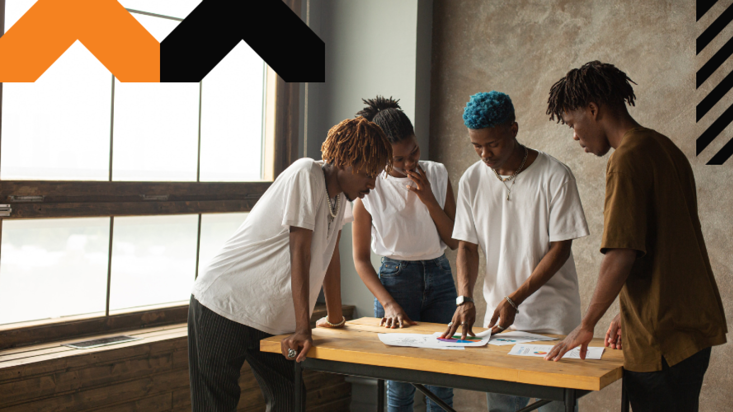 4 coworkers reviewing work over a desk together