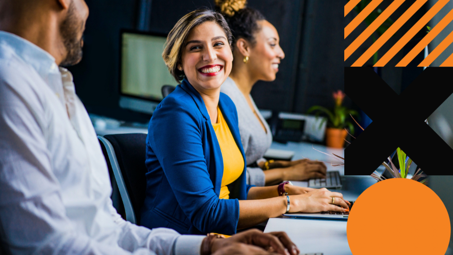 Teammates working at their desk and smiling at each other