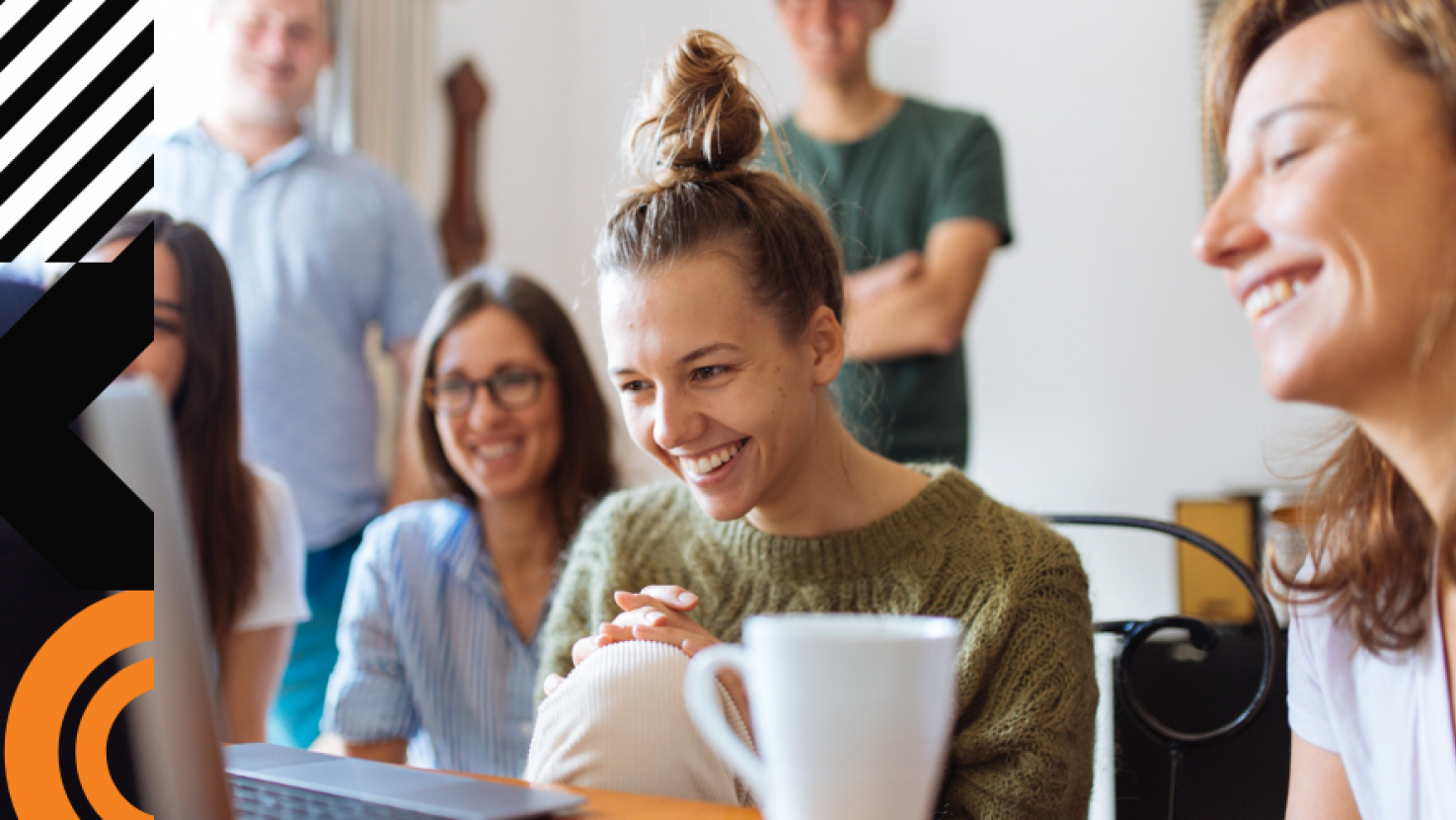 happy coworkers looking at a laptop together