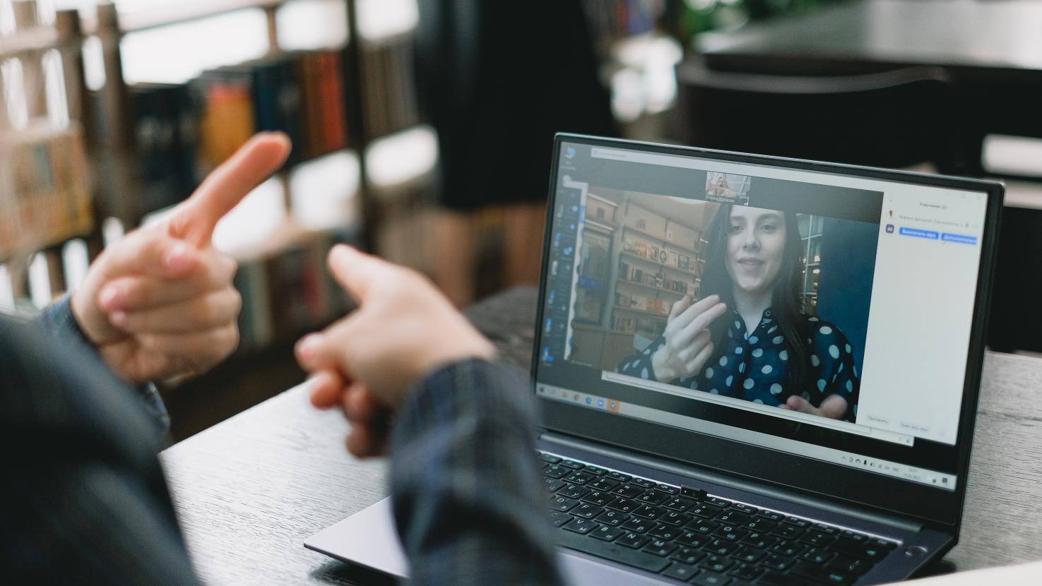 Two people communicating in ASL over a video comms platform