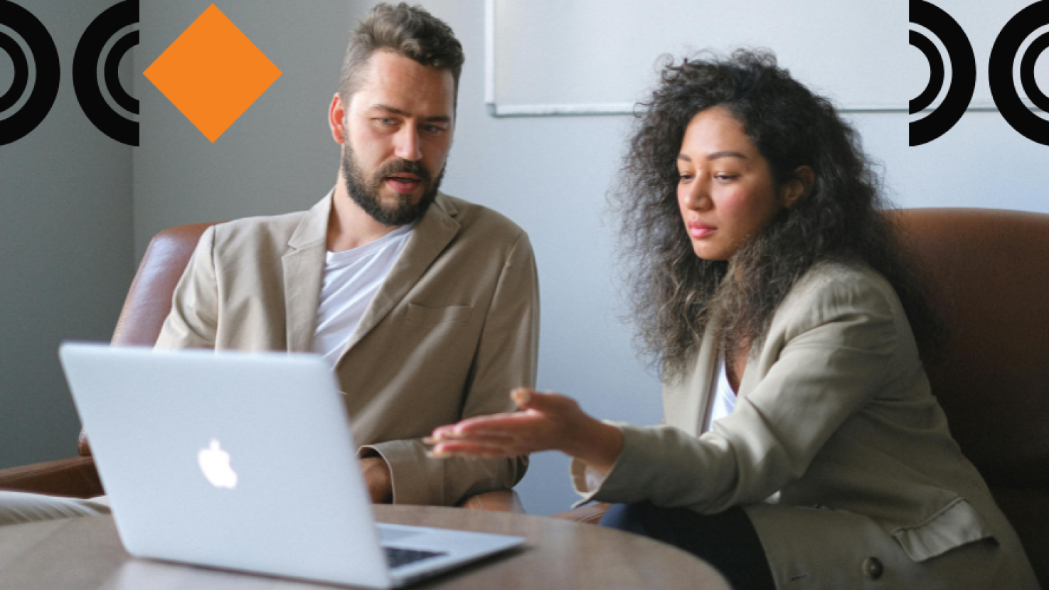 Two colleagues discussing data over a laptop